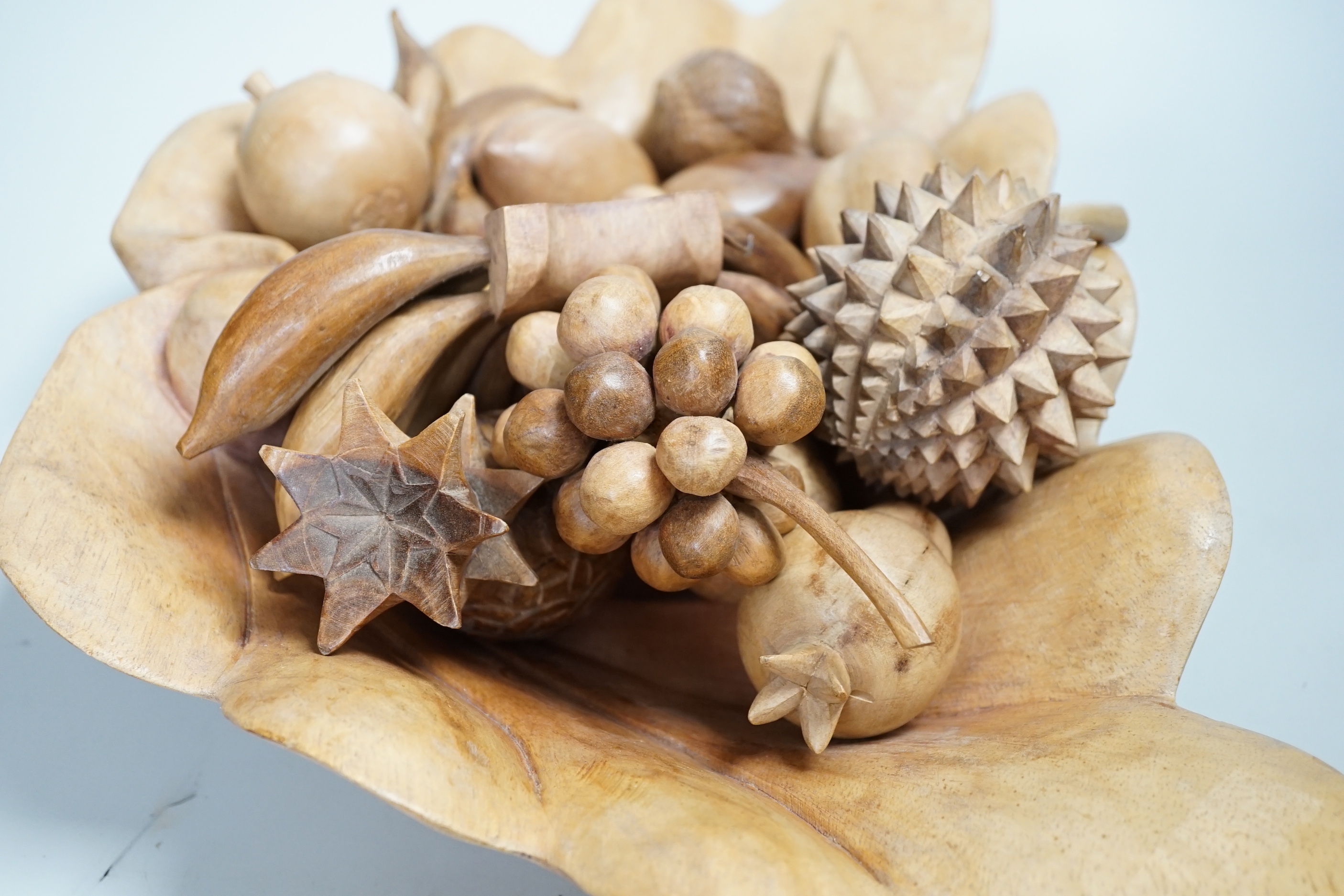 A carved wood bowl and fruit